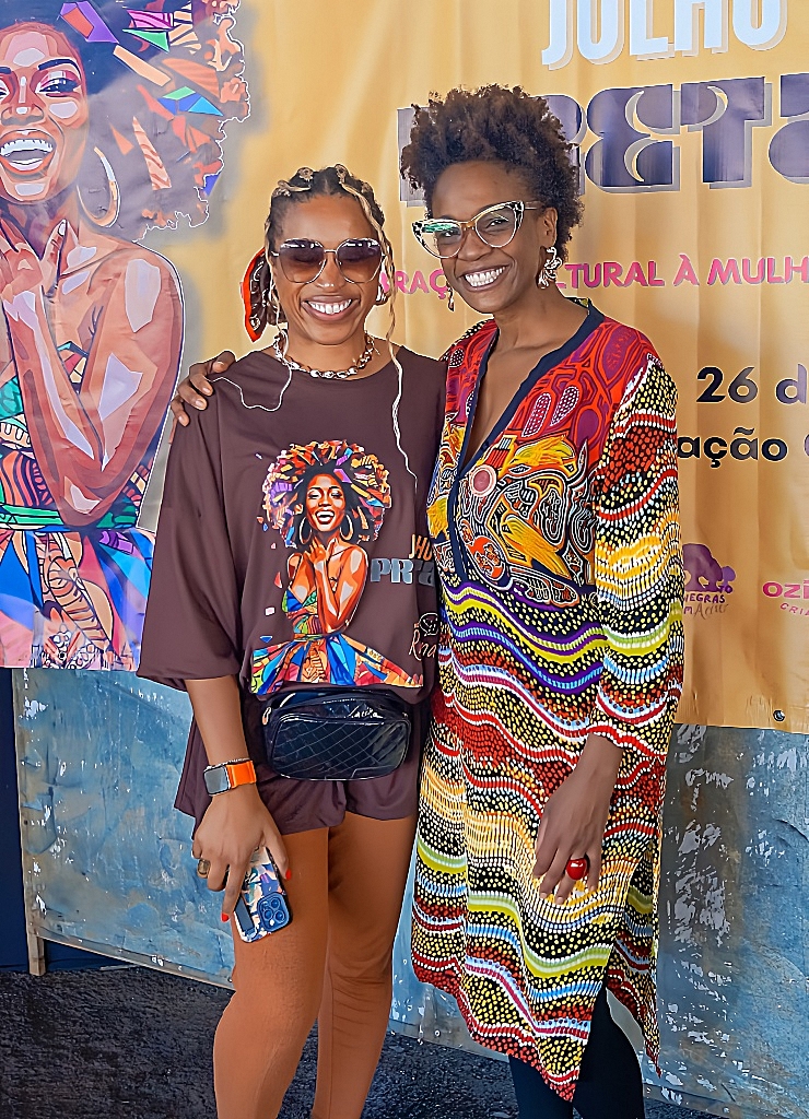 Dupla em frente ao banner