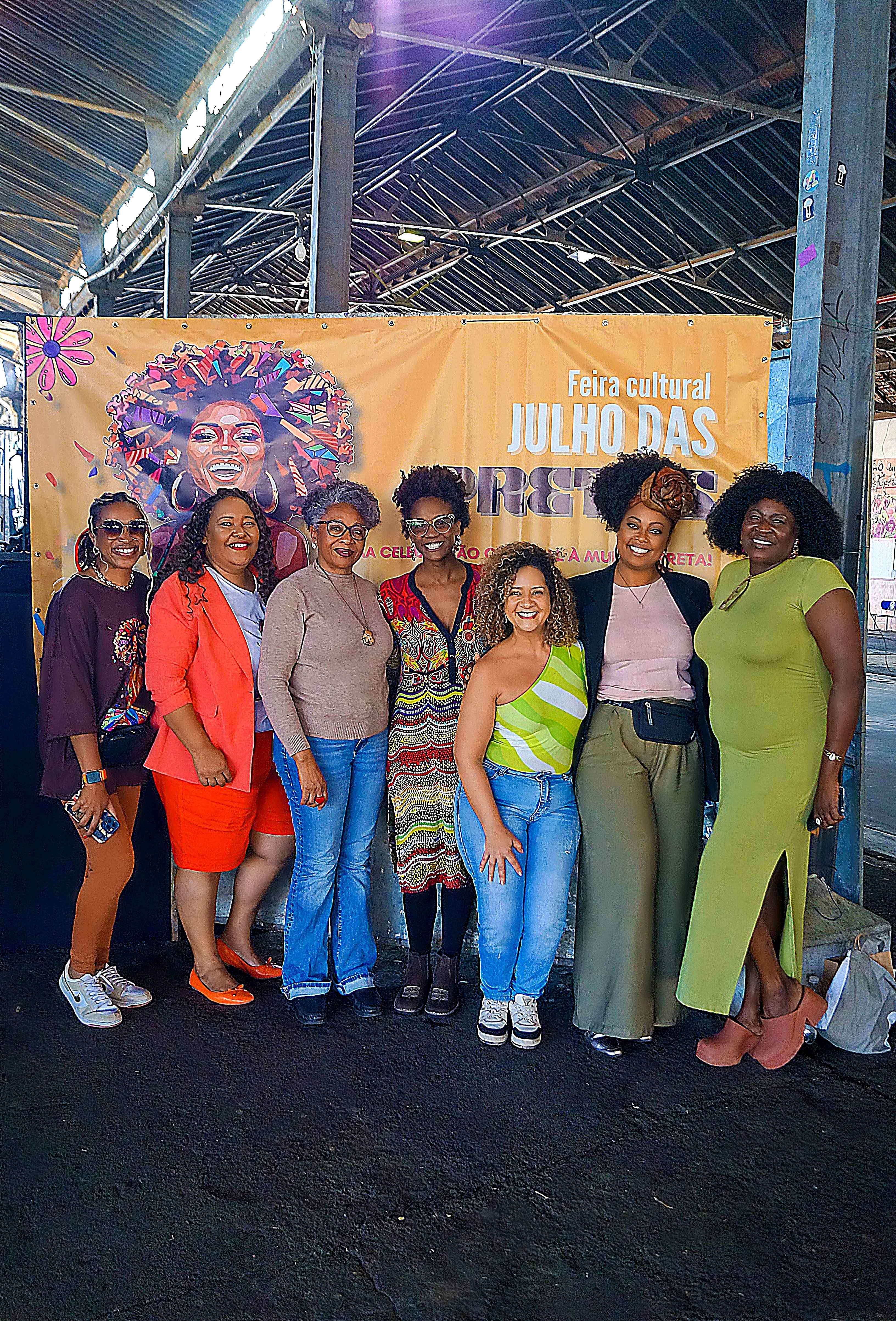 Mulheres em frente ao banner