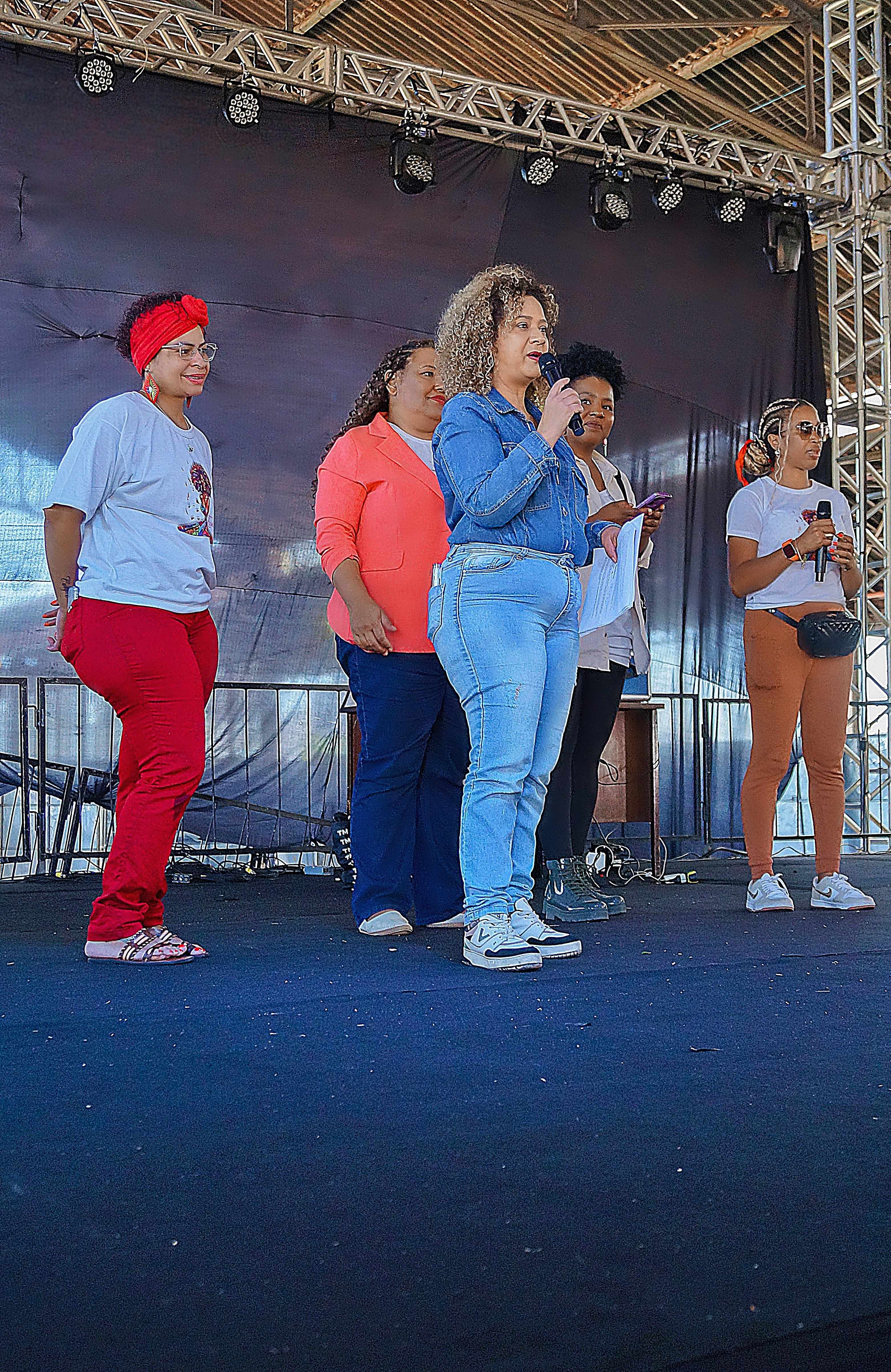 Organizadoras falando no palco