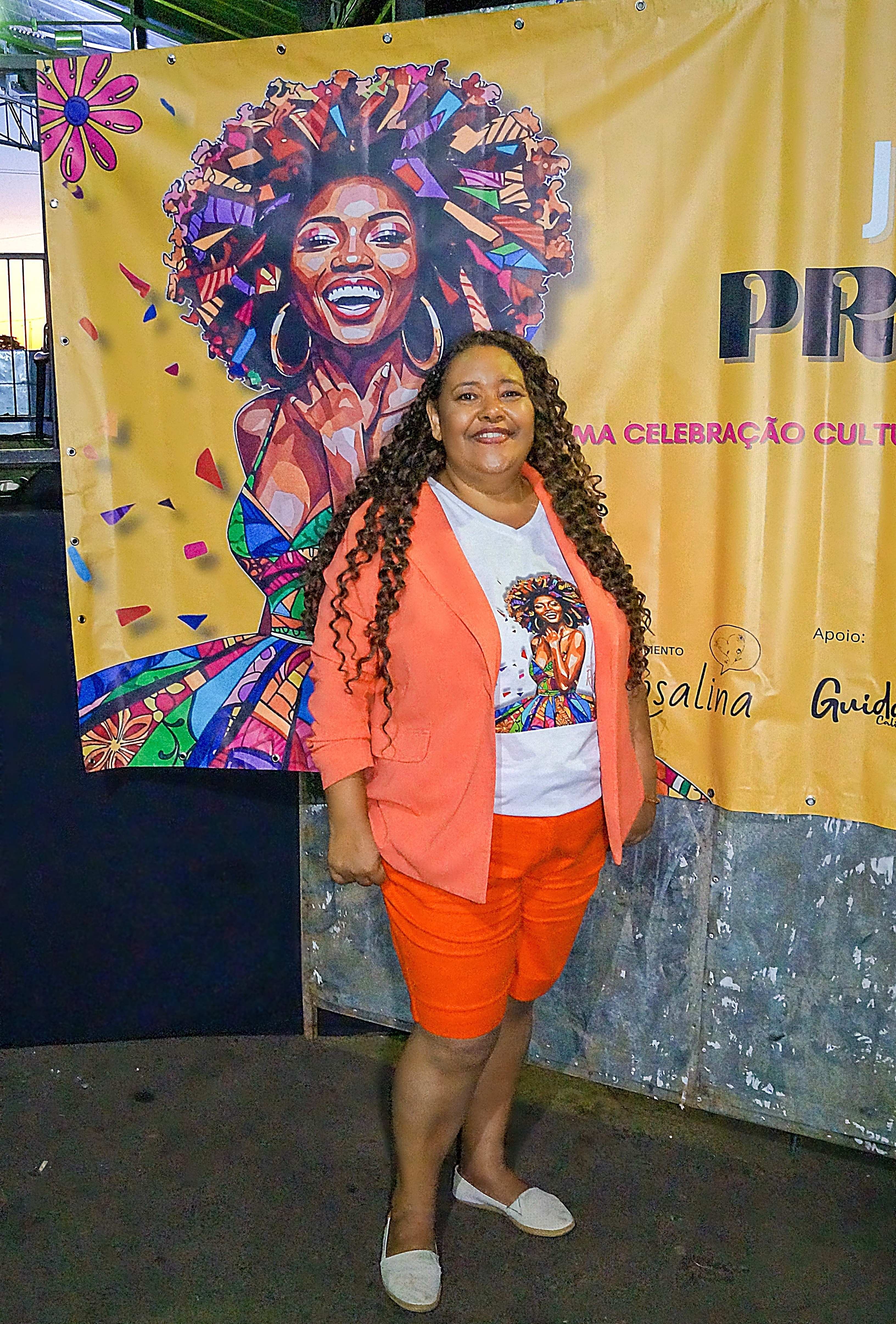 Karla Alexandra em frente ao banner